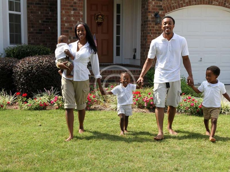 African American family together outside their home